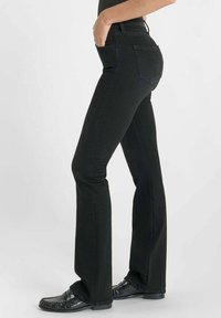 Zwarte flared jeans van denim, met zijzakken en een hoog tailleontwerp. De stof heeft een gladde textuur met subtiele stikdetails.