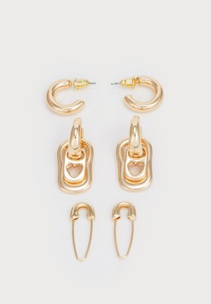 Goldfarbene Ohrringe im Set mit Hoop- und Charm-Designs. Strukturierte Oberflächen mit herzförmigen Ausschnitten und einem sicheren Verschlussmechanismus.