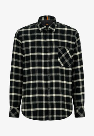 Svartvit rutig flanellskjorta med knappkrage, enkel bröstficka och texturerat tyg. Har en böjd fåll och knapplåsning.