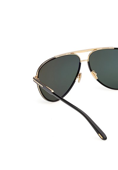 Lunettes de soleil aviateur à monture dorée avec verres vert foncé et branches noires, présentées sur un fond blanc.