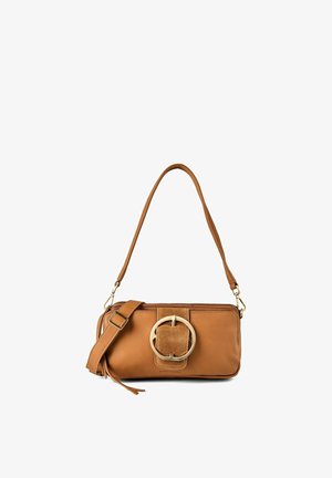 Bolso bandolera de cuero marrón con gran hebilla circular en la solapa frontal y correa ajustable, sobre fondo blanco.