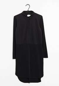 Czarna sukienka z długim rękawem, z kołnierzykiem, posiadająca zapięcie na guziki, zaokrąglony brzeg oraz gładką fakturę materiału. Wiesza się na wieszaku.
