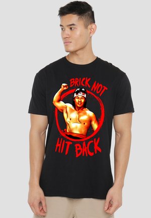 Black cotton t-shirt featuring a graphic print of a muscular figure with a headband, red text reading "BRICK NOT HIT BACK" around it.