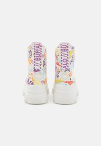 Botas altas blancas con patrones gráficos coloridos, una suela blanca gruesa y una marca pronunciada en el talón y la lengüeta.