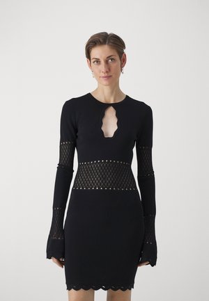 Abito nero con maniche lunghe, caratterizzato da un'apertura a forma di chiave, design a rete intrecciato in vita e bordi ondulati sulle maniche e sull'orlo.