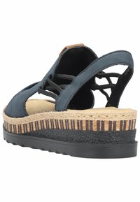 Granatowe sandały na koturnie z otwartym tyłem, z teksturowaną czarną podeszwą, plecioną juttową podeszwą środkową oraz dekoracyjnym sznurowaniem na cholewce.