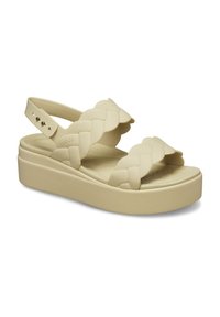 Sandali platform beige con cinturini intrecciati, realizzati in materiale flessibile. Presentano una soletta testurizzata e un cinturino per il tallone regolabile.