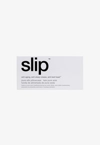 Packaging in una scatola bianca per una federa in seta, con testo nero in evidenza. Include dettagli in diverse lingue sui benefici anti-invecchiamento e per il sonno.