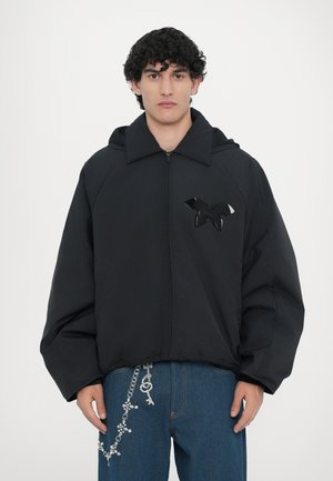Zwarte hoodiejack met een ritssluiting, voorzien van een glanzend zwart vogel embleem op de borst en een relaxte pasvorm, gemaakt van soepel stof.