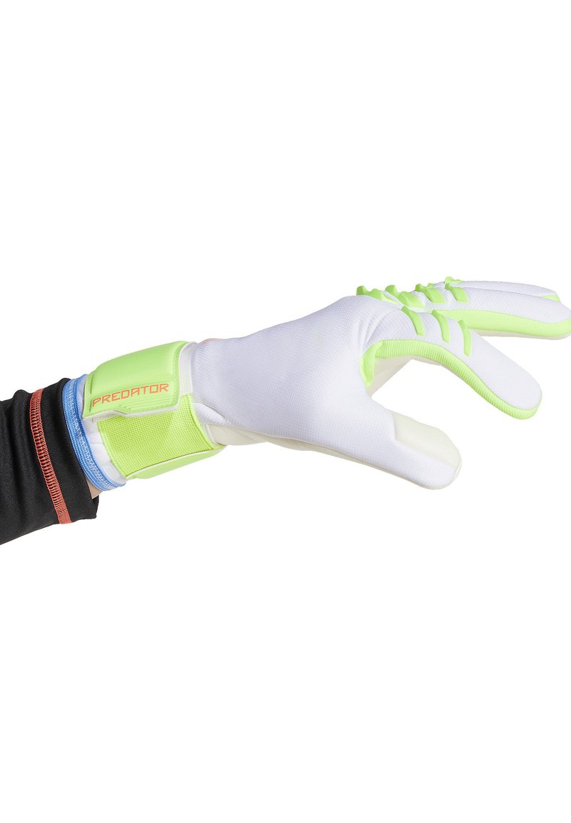 Gant de sport blanc avec une sangle au poignet vert clair, prise texturée sur les doigts, et un petit logo "PREDATOR" en orange sur la sangle.