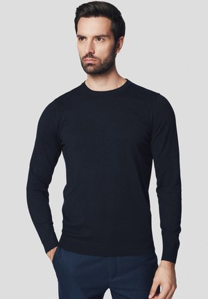 Granatowy sweter z długim rękawem wykonany z gładkiego dzianiny, z okrągłym dekoltem oraz prążkowanymi mankietami i dołem. Minimalistyczny design, bez wzorów.
