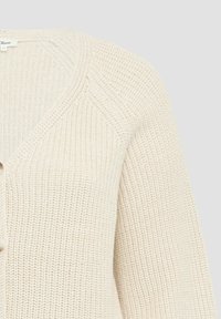 Helle beige gestrickte Strickjacke mit V-Ausschnitt, strukturiertem Muster und einer einzigen Knopfverschluss. Rippdetails an den Ärmeln.