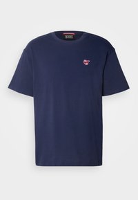 Marineblå bomulds t-shirt med korte ærmer, rund halsudskæring og et lille rødt logo på venstre bryst. Glat tekstur, enkelt design.