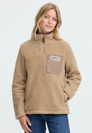 Pull en polaire beige avec un col montant, fermeture zippée mi-hauteur à l'avant, et une poche sur la poitrine. Présente un tissu texturé, des poches latérales, et des poignets ourlés.