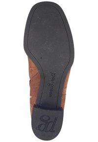 Suela de zapato de gamuza marrón con una suela exterior de goma negra. La marca "paul green" está grabada en la plantilla con un indicador de tamaño.