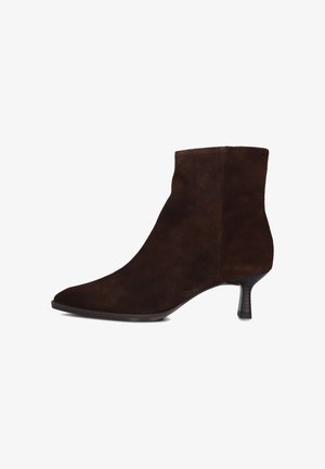 Bruine suède enkellaars met een spitse neus, slanke hak en een gladde textuur; heeft een minimaal ontwerp zonder zichtbare accenten of hardware.
