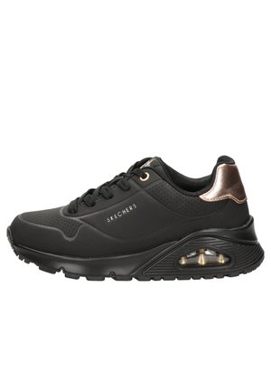 Chaussure de sport noire avec des panneaux perforés, texture lisse et accents en bronze. Dispose d'une semelle rembourrée avec coussin d'air pour le confort.