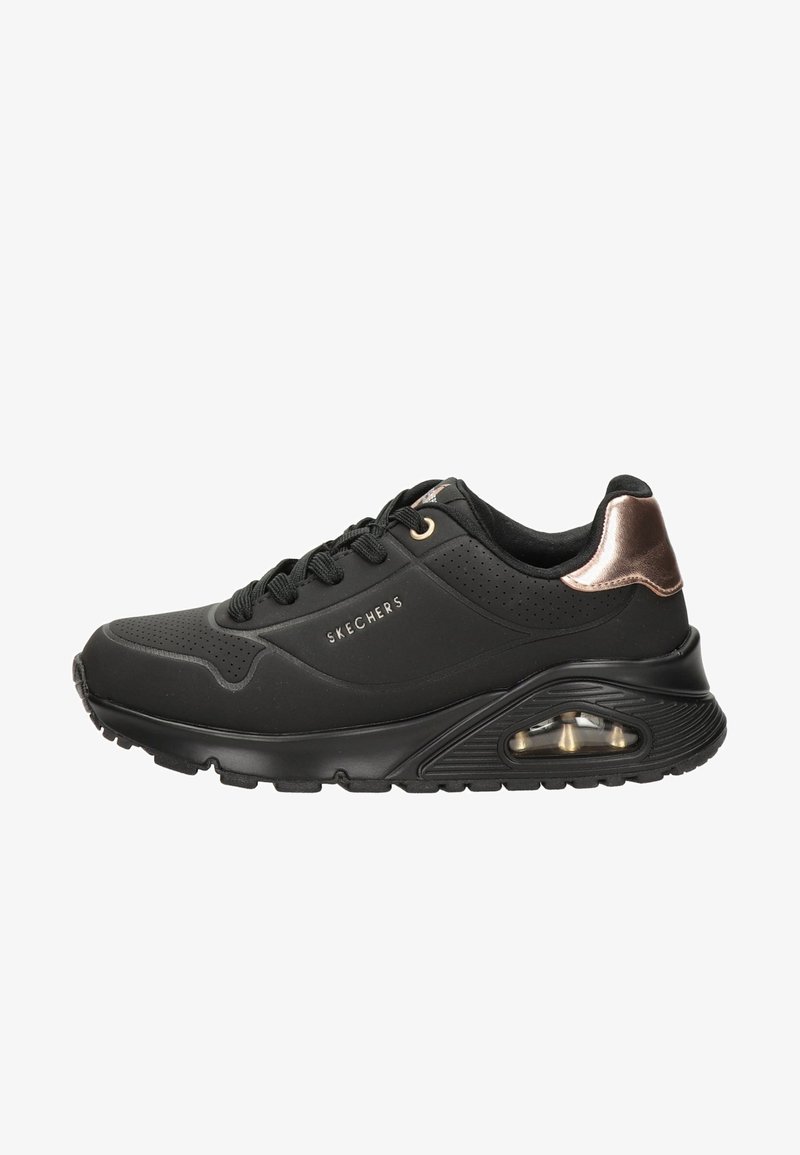 Chaussure de sport noire avec des panneaux perforés, texture lisse et accents en bronze. Dispose d'une semelle rembourrée avec coussin d'air pour le confort.