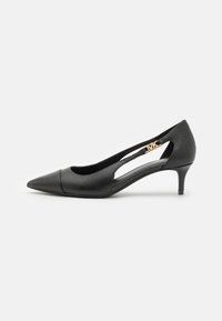 Chaussure à talon haut noire avec un bout pointu, en cuir lisse, présentant des côtés découpés et un petit talon. Détail en métal doré inclus.