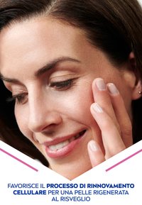 Primo piano di pelle liscia e chiara con trucco naturale. Una mano accarezza leggermente la guancia; la luce soffusa esalta la texture della pelle e i tratti del viso.