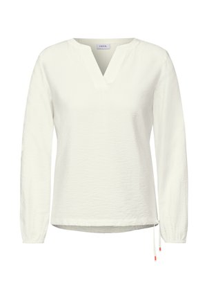 White long-sleeve blouse with a V-neck, textured fabric, a drawstring at the hem, and contrasting orange accents on the drawstring ends.