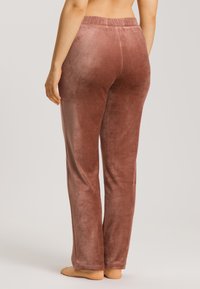 Sametové kalhoty na volno v barvě jemné růžové, s uvolněným střihem, elastickým pasem a hladkou texturou s jemným leskem.