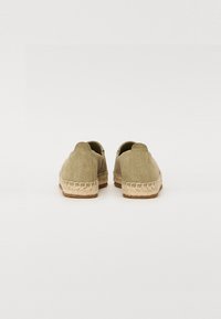 Espadrilles verde oliva con parte superior de ante, suela envuelta en yute y detalle de logotipo en el talón, con puntera redondeada y diseño sin cierre.