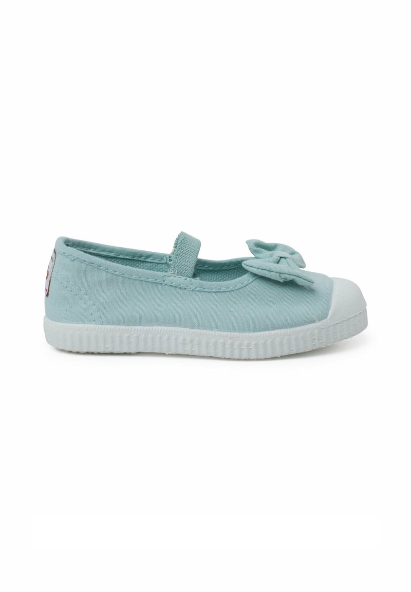 Bailarina de lona azul claro con acento de lazo, banda elástica y suela de goma blanca. Punta redondeada, textura suave, diseño minimalista.