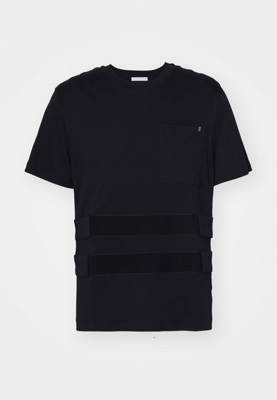 T-shirt nero con collo rotondo, maniche corte, taschino sul petto e tre strisce orizzontali di velcro nero sulla parte anteriore. Tessuto liscio.