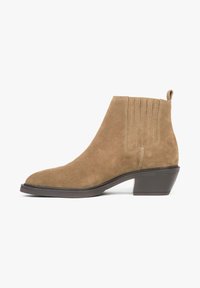 Tan suede ankle boot with a pointed toe and a low stacked heel. Features vertical stitching on the sides and a pull tab at the rear.