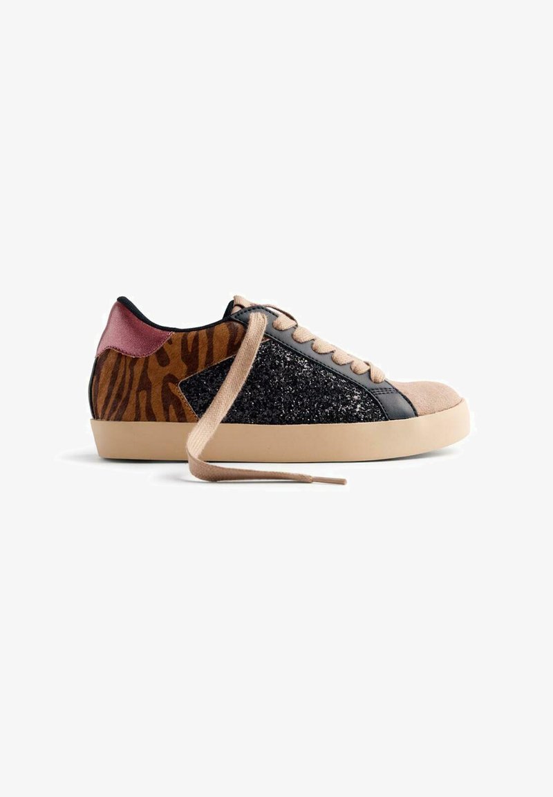 Zapatilla que presenta una mezcla de materiales: gamuza beige, purpurina negra y detalles a rayas de tigre marrón. Incluye cordones beige y un talón rosa.