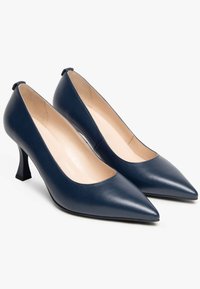 Pompes en cuir marine avec un bout pointu, un design découpé subtil et un petit talon noir. Texture lisse avec une finition mate.