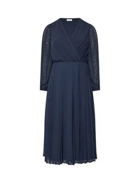 Laivastonsininen mekko, jossa on kietaisutyyppinen yläosa, pitkät läpinäkyvät hihat ja pleatattu hame, jossa on teksturoitu pistekuvio. Pehmeä, virtaava kangas.