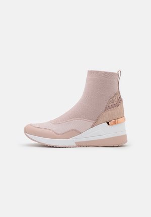 Stivaletto sneaker alto con tomaia in maglia beige, suola platform bianca e dettaglio in oro rosa sul tallone, mostrato di profilo.