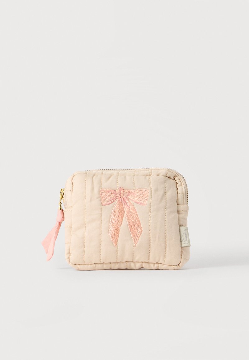 Piccola borsetta beige trapuntata con un fiocco rosa ricamato sul davanti e un tiralampo in tessuto rosa su una cerniera dorata.