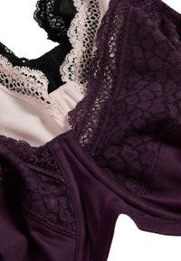 Büstenhalter in Dunkellila mit schwarzen Spitzenakzenten und hellrosa Stoff. Verfügt über gemusterte Spitze, glatte Textur und elastische Details.