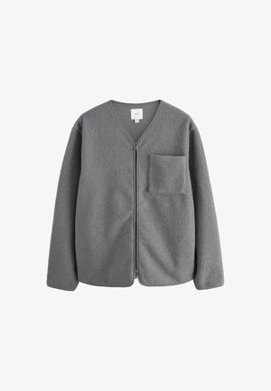 Grå fleecejacka med dragkedja framtill och V-ringning. Har långa ärmar och en ficka på vänster bröst. Mjuk, texturerad tyg.