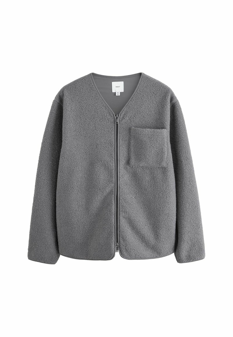 Veste en polaire grise avec fermeture éclair sur le devant et col en V. Comprend des manches longues et une poche unique sur la poitrine gauche. Tissu doux et texturé.