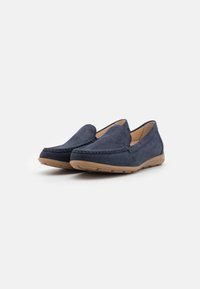 Marineblaue Mokassins aus weichem Wildleder, mit einem gesteppten Mokassinschnitt und einer hellbraunen Gummisohle für besseren Halt und Komfort.