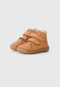 Botas de niño en tonos beige con doble tira de velcro y forro de forro polar, suelas de goma, exhibidas lado a lado sobre un fondo blanco liso.