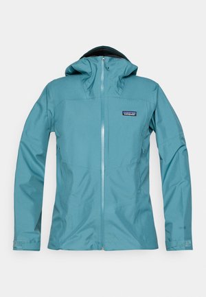 Tamsiai mėlynas vandeniui atsparus džemperis su kapišonu, užtrauktuku priekyje ir logotipu. Yra lygi tekstūra ir prigludę rankovės su reguliuojamais rankogaliais.