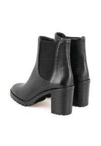 Bottines en cuir noir avec des panneaux texturés, des bouts ronds et des talons épais. Équipées d'une semelle en caoutchouc robuste pour une bonne adhérence.