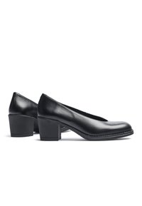Zapatos de tacón cuña de cuero negro con punta redonda y diseño en forma de V, que cuentan con una textura suave y un sutil detalle de costura a lo largo de la suela.