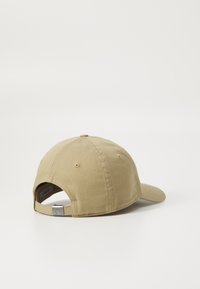 Beige színű pamut baseball sapka ívelt szélekkel, hátsó állítható pánttal és szellőző lyukakkal a felső részén.