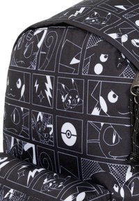 Black fabric backpack featuring a grid pattern of various Pokémon illustrations in white. Includes detailed graphical accents and textures.