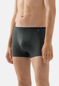 Mörkgrå herrboxer med en texturerad rutmönster, med en midjebandets logotyp och en åtsittande design för komfort och stöd.