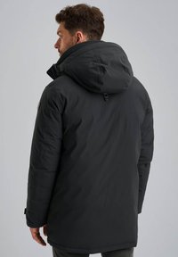 Zwarte gewatteerde winterjas met capuchon, met een gladde textuur, ritssluiting en subtiele logodetail op de mouw.