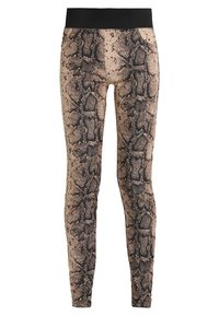 Leggings con estampado de piel de serpiente que presentan un diseño ajustado, en colores beige y negro, y una amplia cinturilla negra para mayor comodidad y soporte.