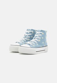 Blå högskurna sneakers med vita snören, med ett prydnadsmönster av tusensköna, vita gummikåpor och en texturerad plattformssula med svarta accenter.