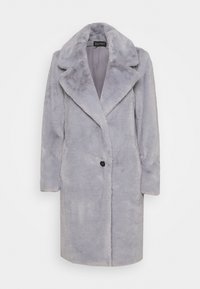 Grå fuskpälsjacka med urklippt krage, ensamt svart knappstängning och långa ärmar. Mjuk textur och medellång design.